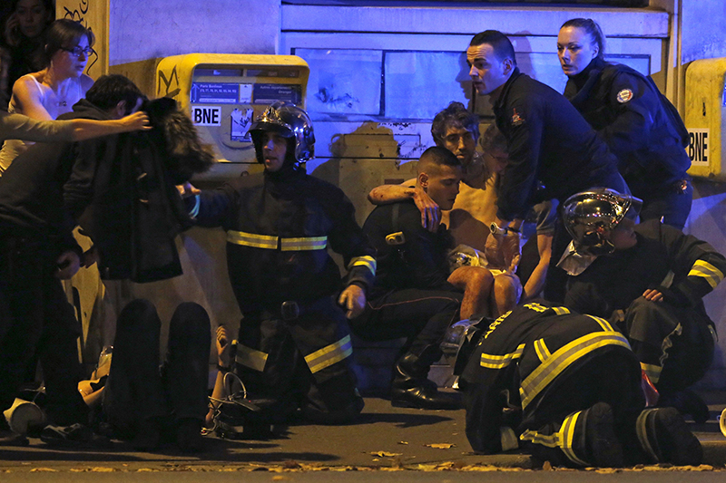 Сотрудники французской полиции оказывают помощь раненым у концертного зала Bataclan в 11-м округе Парижа