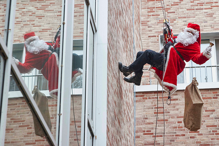 Спасатель в костюме Санта Клауса поздравляет детей в Университетской клинике Эппендорф в Гамбурге, Германия