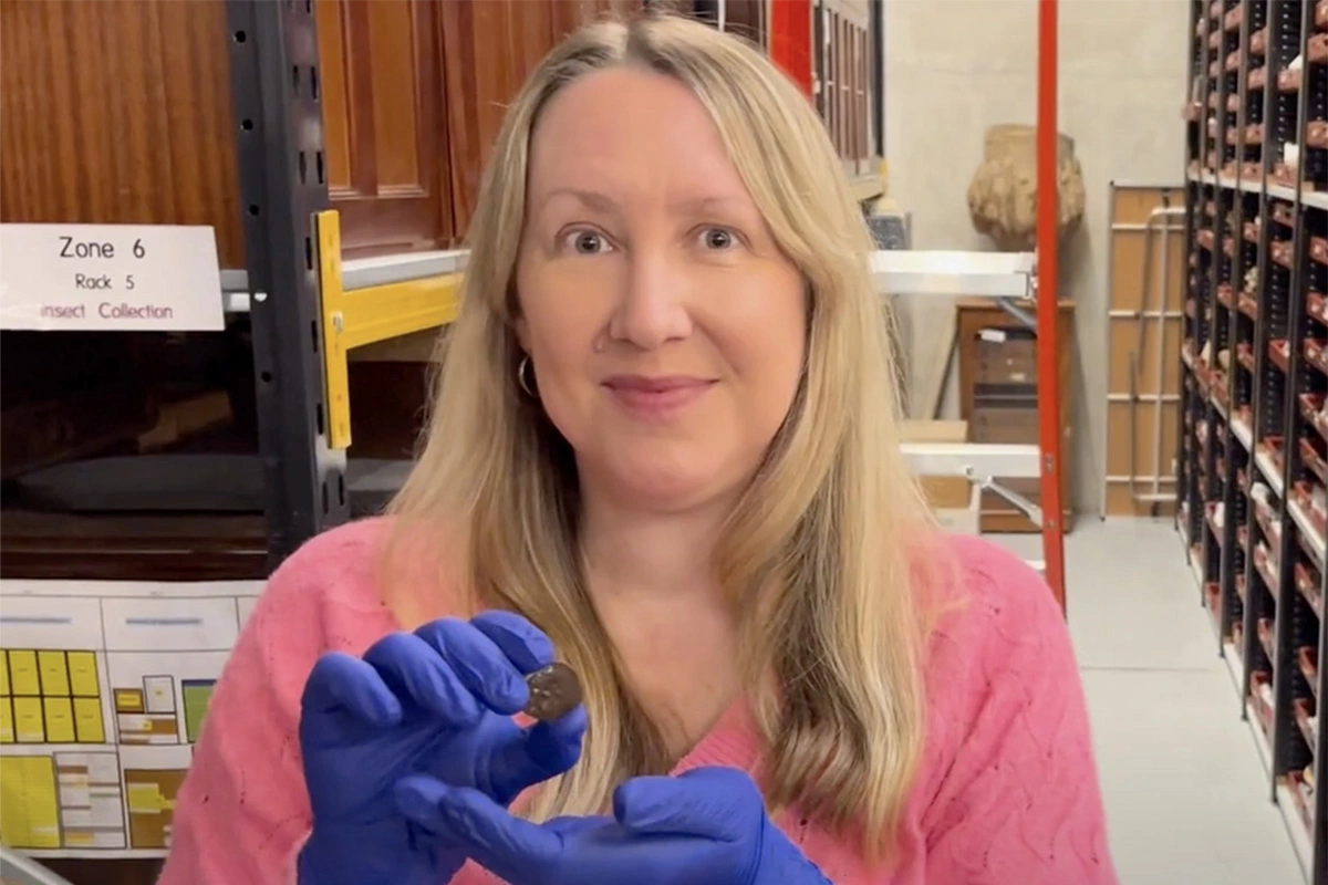 Кэт Бакстер, куратор отдела археологии и нумизматики Музея и галерей Лидса, показывает лицевую сторону древней монеты