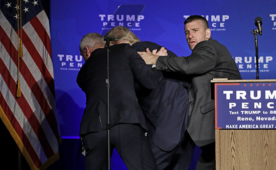 Агенты безопасности уводят кандидата в президенты США&nbsp;Дональда Трампа со сцены. 5 ноября 2016 года


