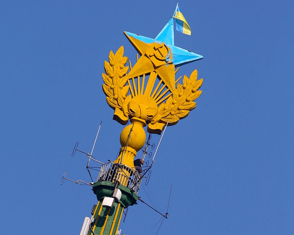 Звезда, раскрашенная в цвета флага Украины, и флаг Украины, вывешенный на жилом доме на Котельнической набережной