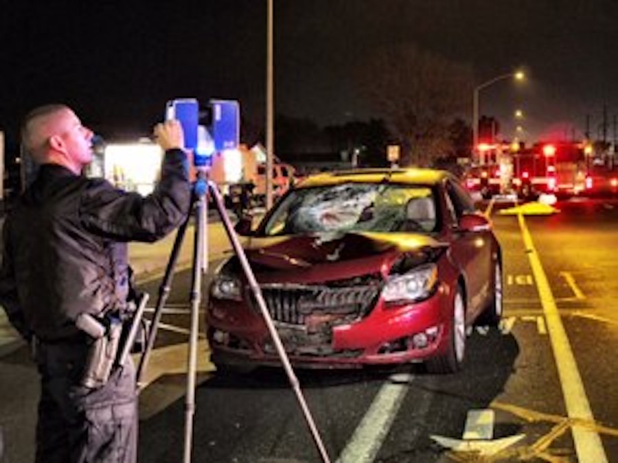 Офицер фиксирует место аварии лазерным сканером, США