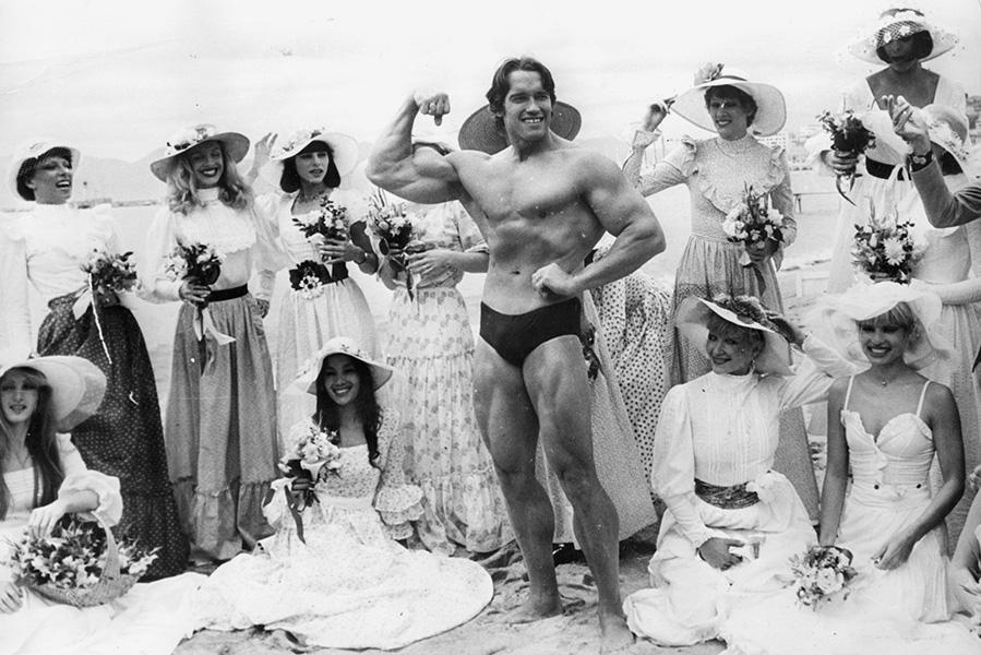 Арнольд Шварценеггер на каннском пляже во время кинофестиваля с девушками из кабаре «Фоли-Бержер», 1977 год