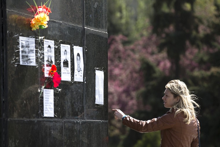 Женщина смотрит на портреты погибших пророссийских активистов, прикрепленных к постаменту памятнику Ленину. Точное количество убитых во время спецоперации в Славянске остается неизвестным. Местные СМИ сообщали о десяти погибших сторонниках федерализации.