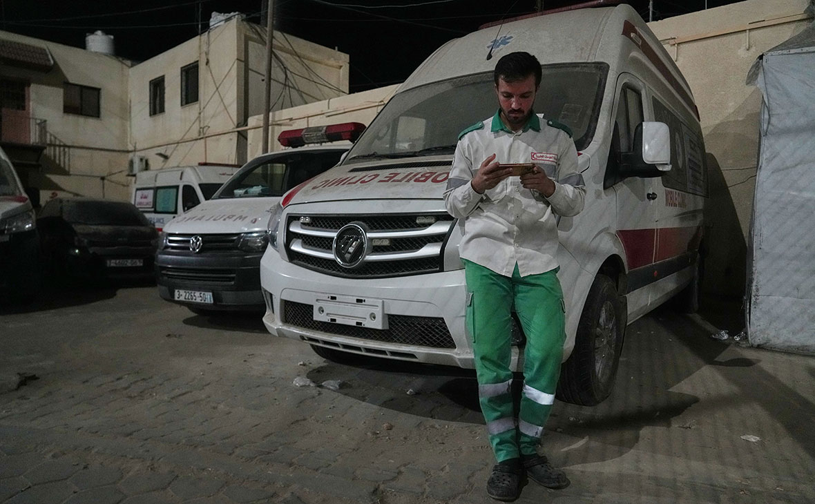 Палестинский фельдшер следит за новостями по телефону в Дейр-эль-Балахе, в центральной части сектора Газа