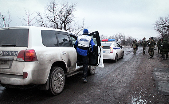Автомобили ОБСЕ и полиции, которые сопровождают колонну автобусов, прибывших в Дебальцево для эвакуации местных жителей из зоны боевых действий.
