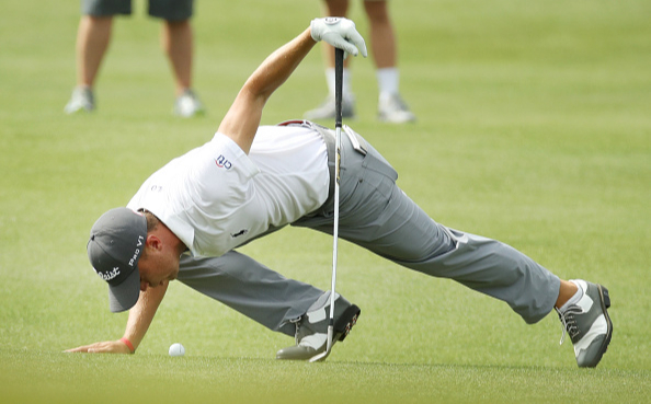 Игрок в гольф изучает положение мяча на поле