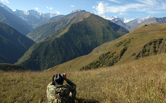 Местный житель смотрит в&nbsp;бинокль на&nbsp;горы в&nbsp;Шаройском районе Чеченской республики


