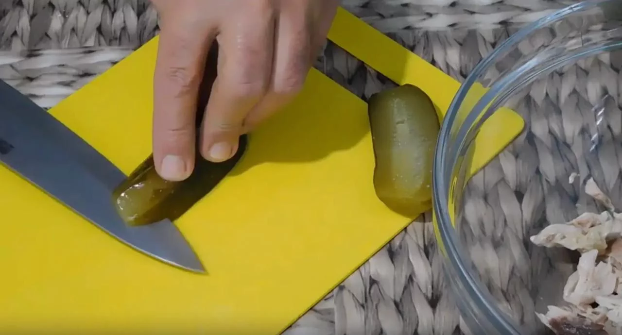 Мелко нарежьте соленые огурцы