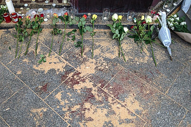 Принесенные парижанами цветы на месте убийства у ресторана Сarillon