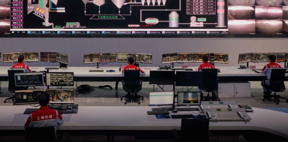 Рабочие мусоросжигательной электростанции наблюдают за сжиганием отходов в центральной диспетчерской