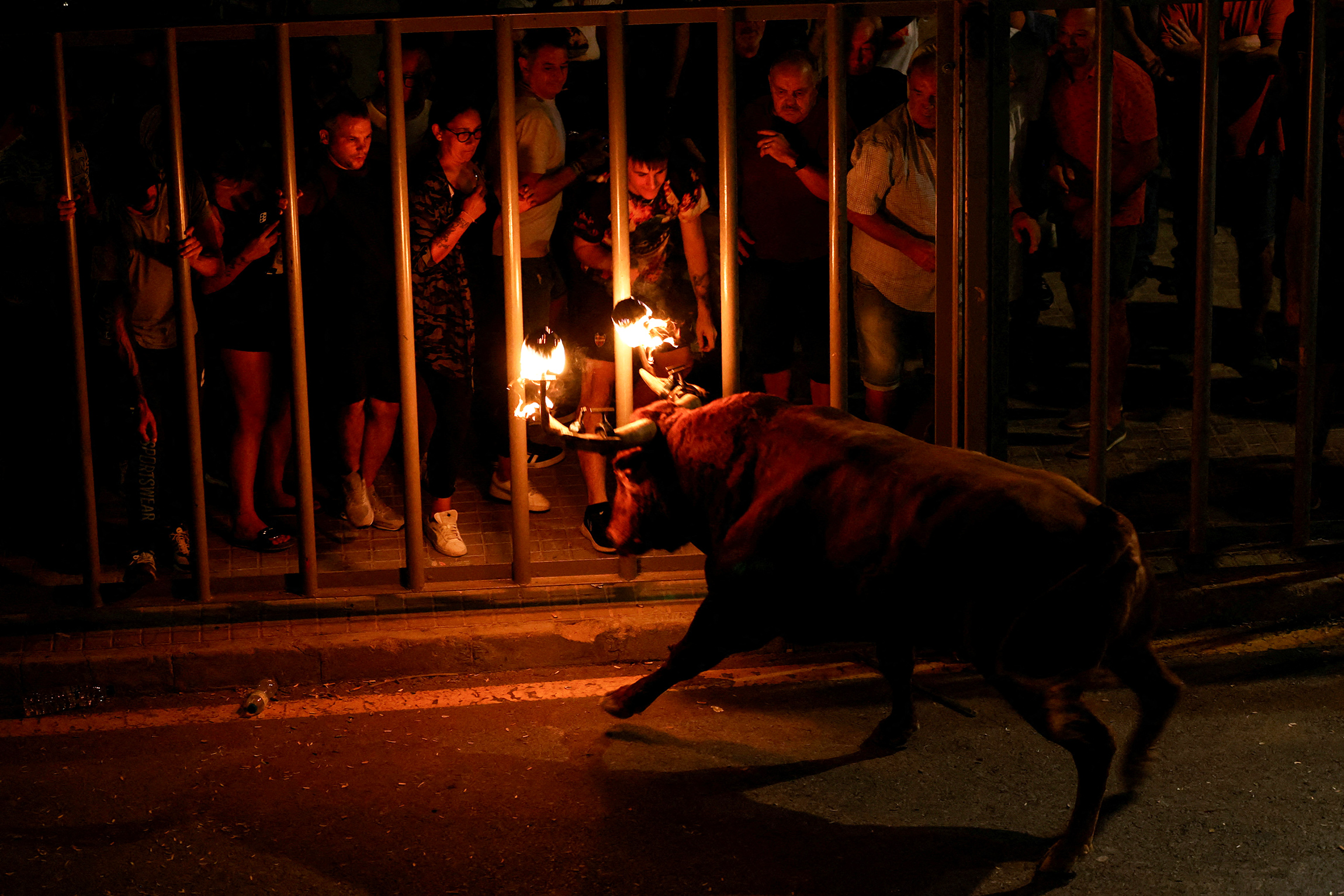 Прохожие смотрят на быка с пылающими рогами 17 сентября&nbsp;во время фестиваля bou embolat, который был запрещен в Валенсии в 2016 году, но восстановлен новым региональным правительством&nbsp;в Карпесе, северная Валенсия, Испания
