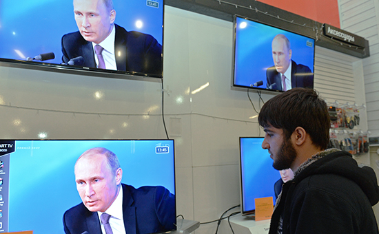 Житель Грозного смотрит пресс-конференцию президента РФ Владимира Путина в торговом центре города