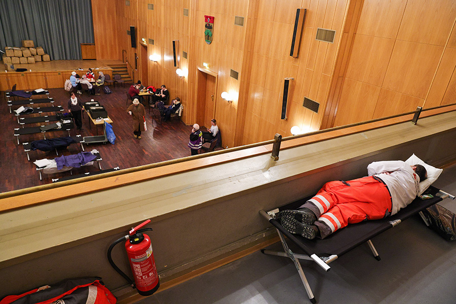 Сотрудник Немецкого Красного Креста отдыхает в пункте оказания помощи в районном управлении Штеглиц-Целендорф в Берлине