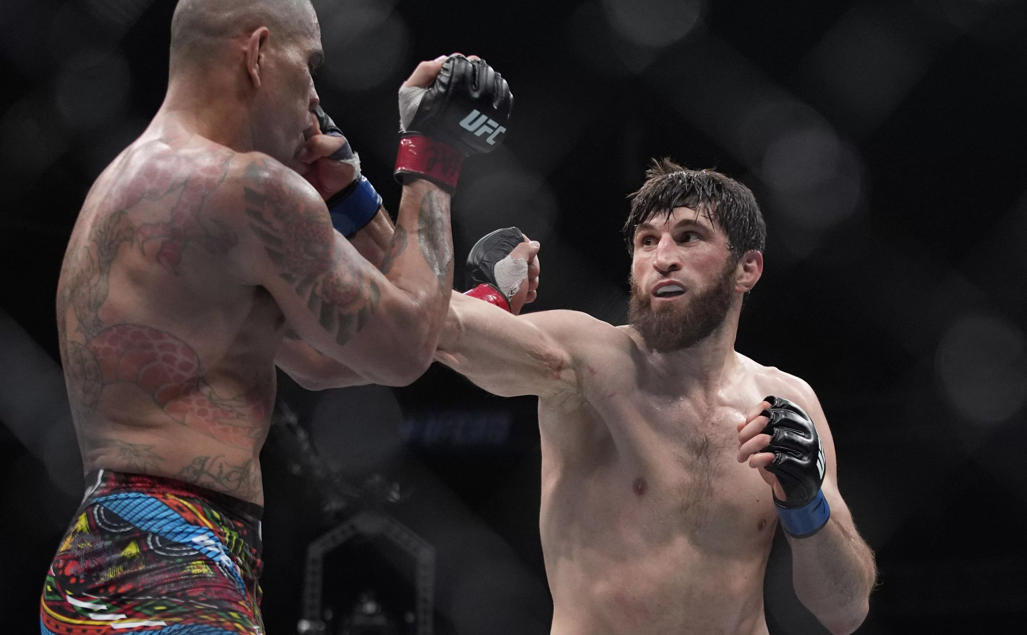 Бразильский боец Алекс Перейра и российский боец Магомед Анкалаев (слева направо) в поединке Абсолютного бойцовского чемпионата (UFC) в полутяжелом весе. (AP/TASS)