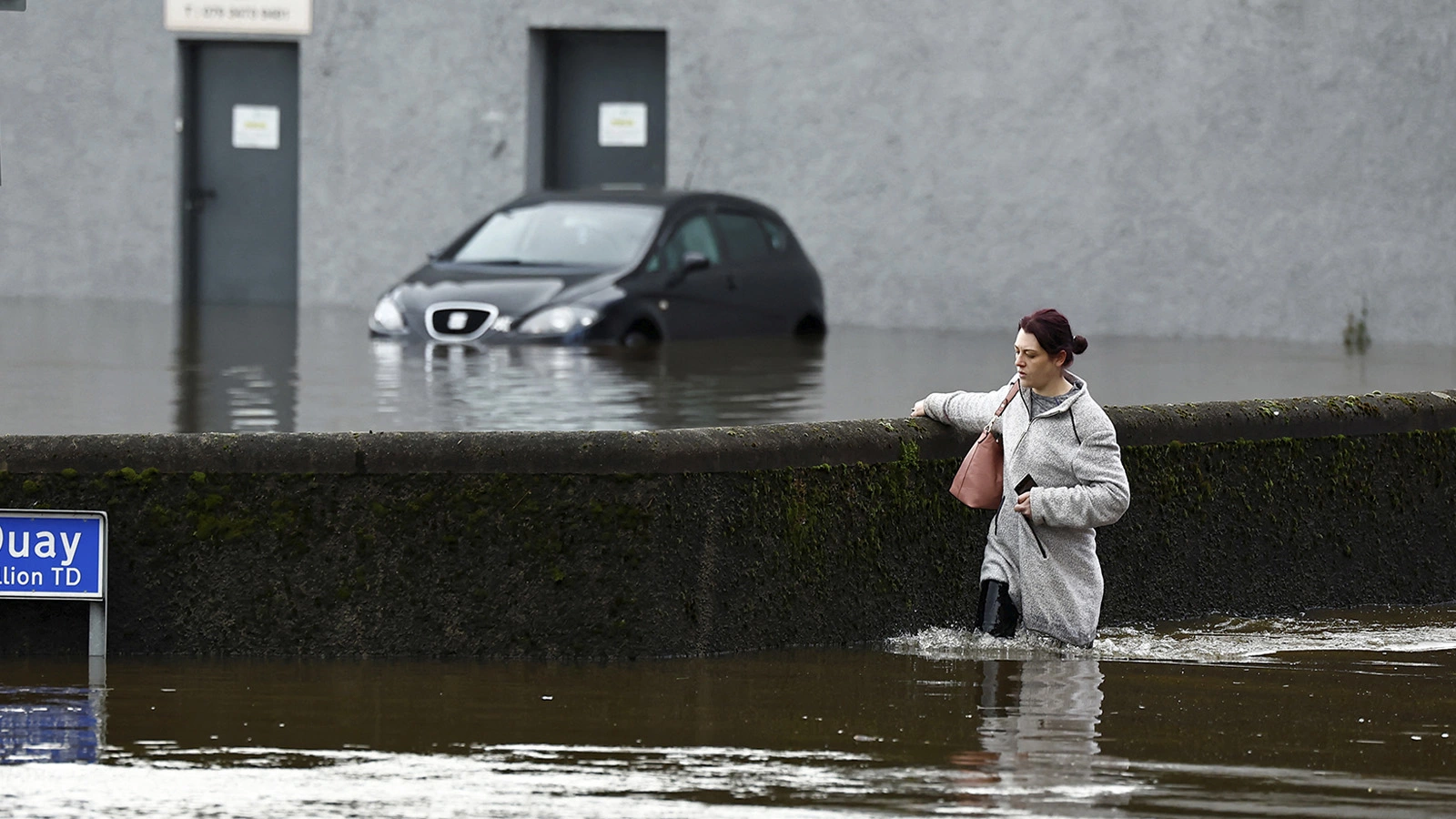 <p>На фото: жительница Ньюри (Северная Ирландия) идет по городу после наводнения</p>