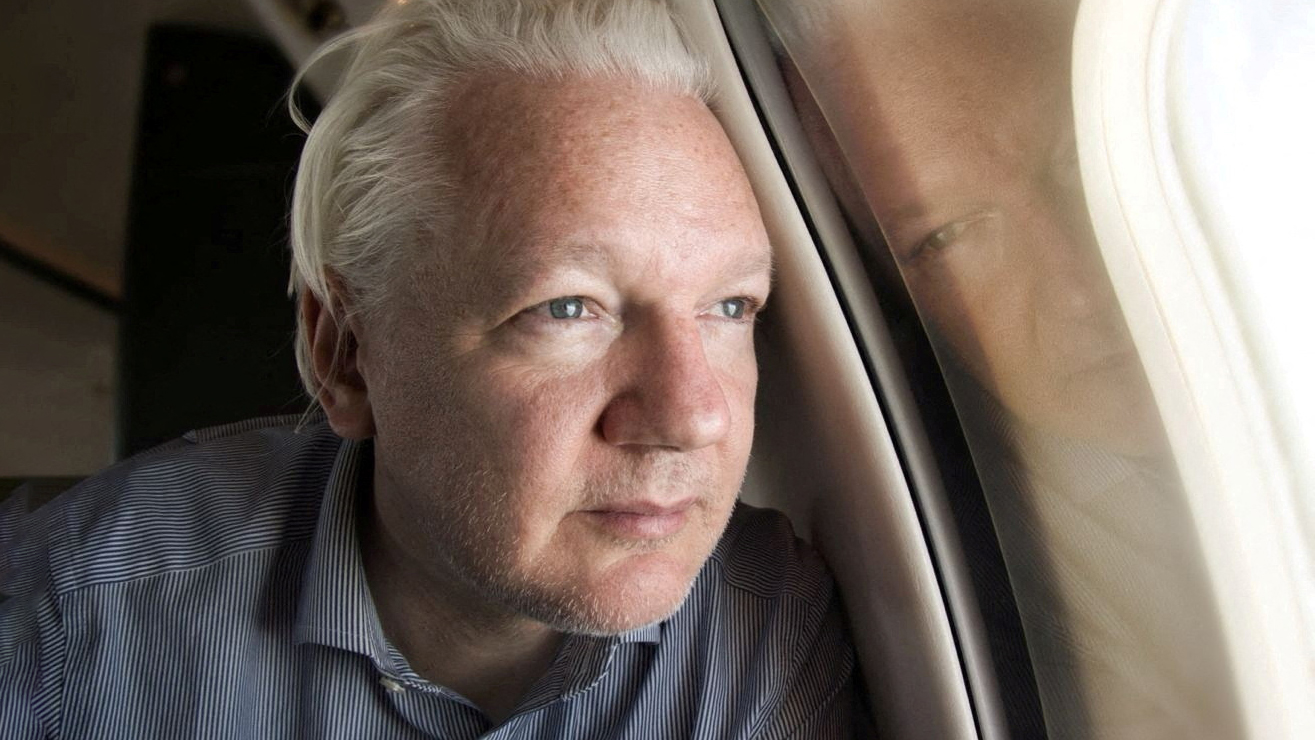 Основатель WikiLeaks Джулиан Ассанж смотрит в окно самолета, который готовится к посадке в аэропорту Бангкока на дозаправку. 25 июня 2024 года