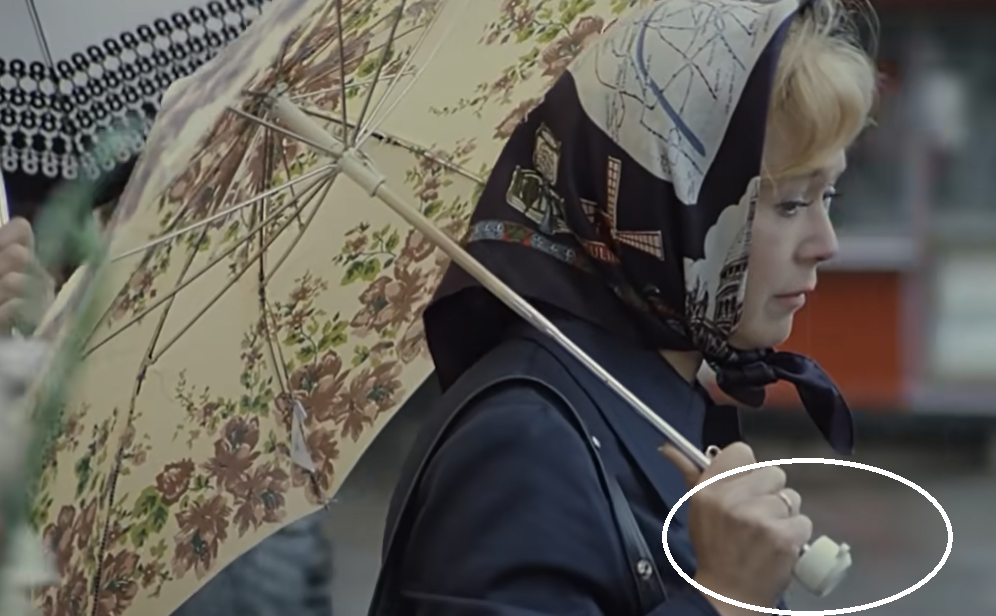 Сначала ручка зонта в руках героини белая и круглая. Кадр из фильма «Служебный роман»