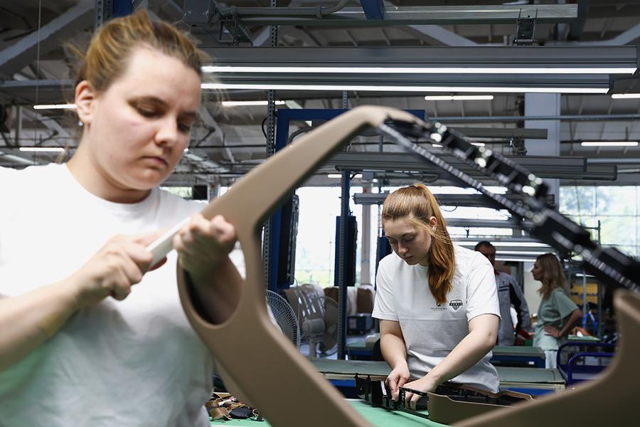 Работники во время производства отделки сидений и элементов интерьера из натуральной кожи для автомобилей «Аурус» и «Лада Аура» на предприятии «Транспортные интерьерные системы»