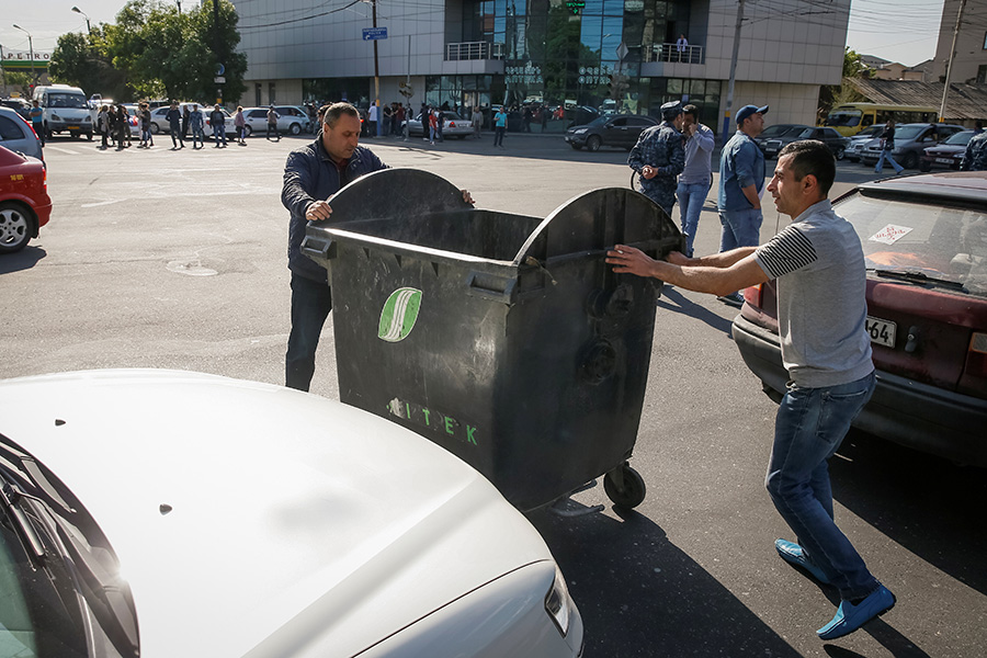 Для того чтобы блокировать движение по магистралям, активисты устанавливают на дорогах мусорные баки.