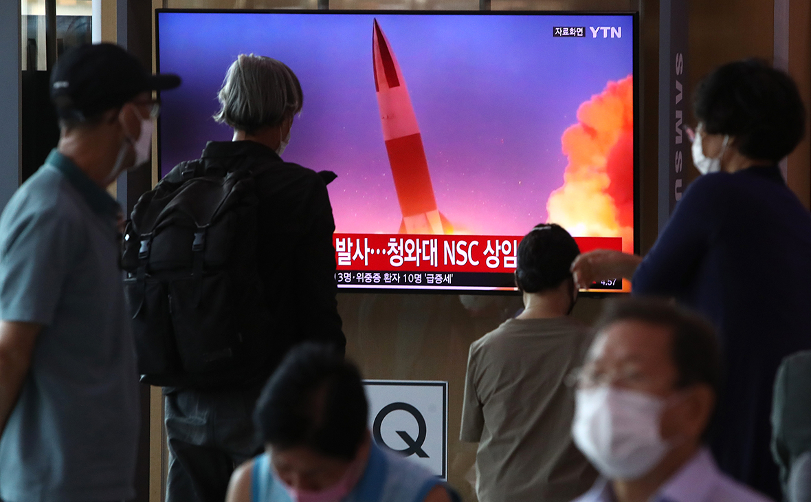 Люди смотрят телевизор на вокзале Сеула, показывающий изображение запуска северокорейской ракеты
