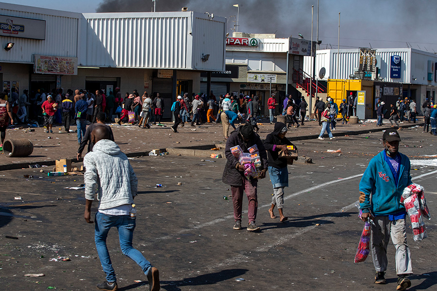 Президент ЮАР Сирил Рамафоза назвал продолжающиеся беспорядки крупнейшими с начала 1990-х годов. По данным агентства Bloomberg на начало недели, разграблению подверглись по меньшей мере 200 магазинов. На фото люди выносят товары из торгового центра, расположенного к югу от Йоханнесбурга



