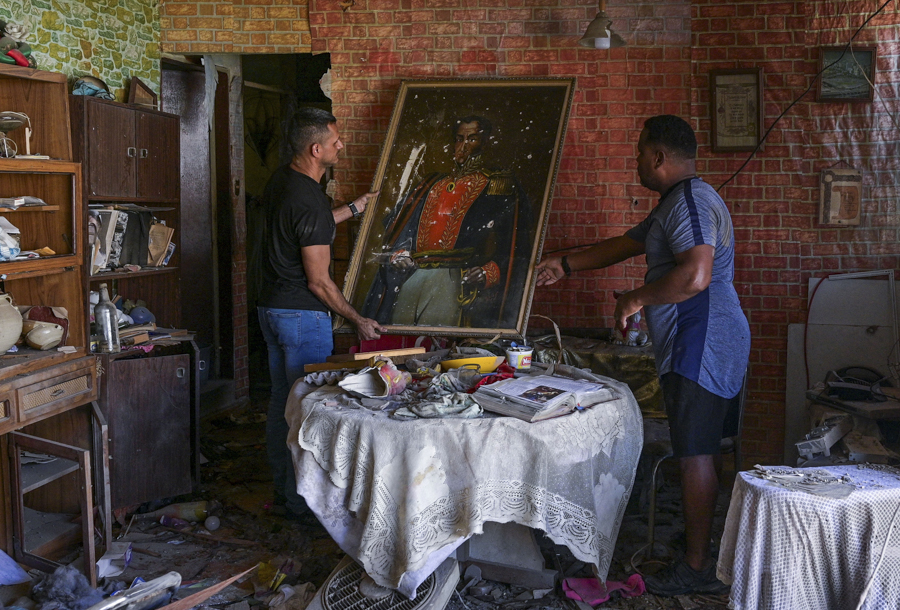 Мужчины с портретом&nbsp;Симона Боливара в поврежденной квартире. Город Катия-ла-Мар в штате Ла-Гуайра, недалеко от главного аэропорта Венесуэлы.