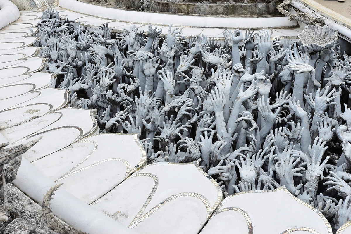 К главному зданию можно попасть, перейдя мост через небольшое озеро: сотни протянутых в агонии рук символизируют человеческие желания, страдания и ад