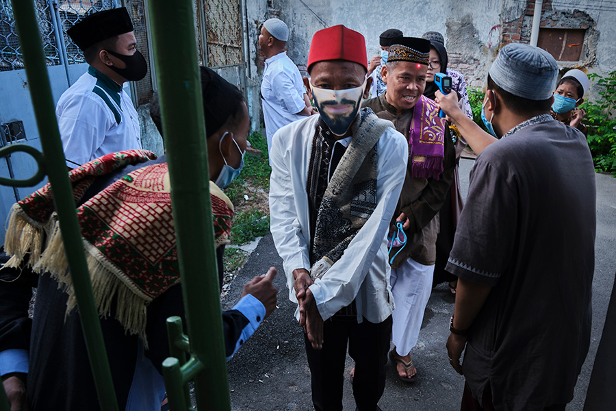Мусульманам проверяют температуру перед входом в местную мечеть в Джакарте, Индонезия




