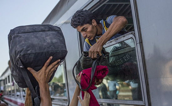 Мигранты грузят свой багаж в поезд недалеко от границы Хорватии и Венгрии