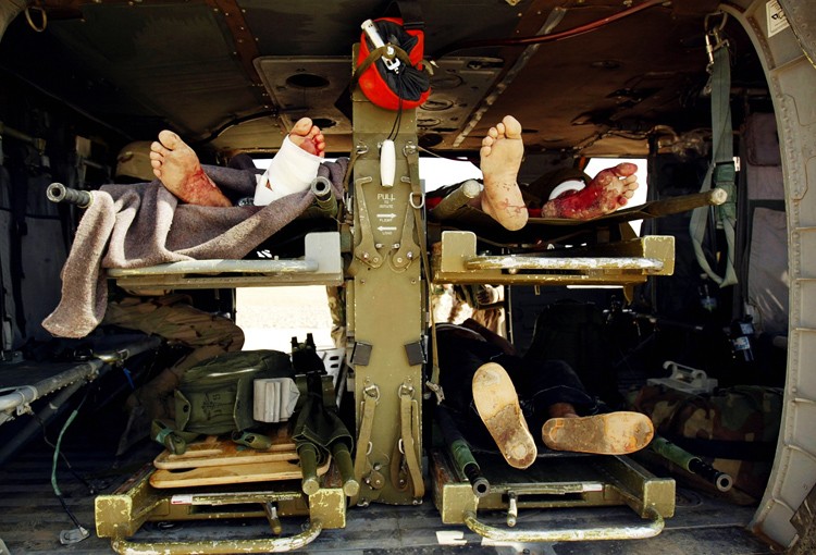 Иракские заключенные, раненые при минометном обстреле 20 апреля 2004г., погружены в медицинский вертолет и ожидают эвакуации.