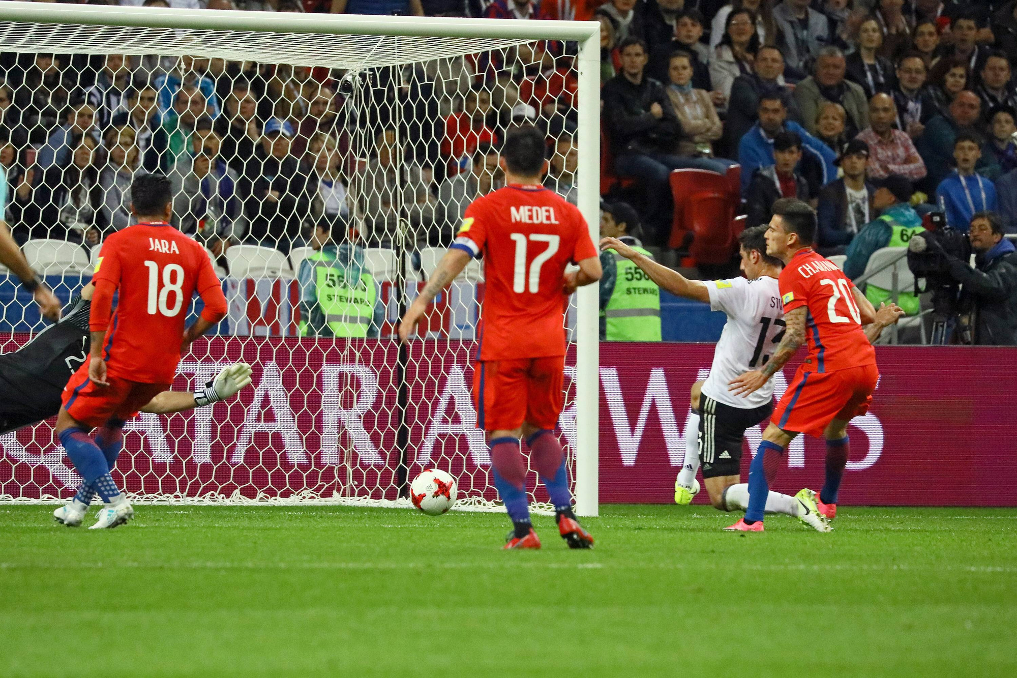 Атакующий хавбек сборной Германии Ларс Штиндль (№&nbsp;13) опережает чилийских защитников и сравнивает счет