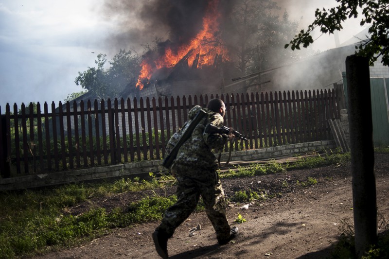 Антиправительственный активист под обстрелом. Он спешит на подмогу ополченцам, которые ведут бой с украинской армией в Лисичанске. 