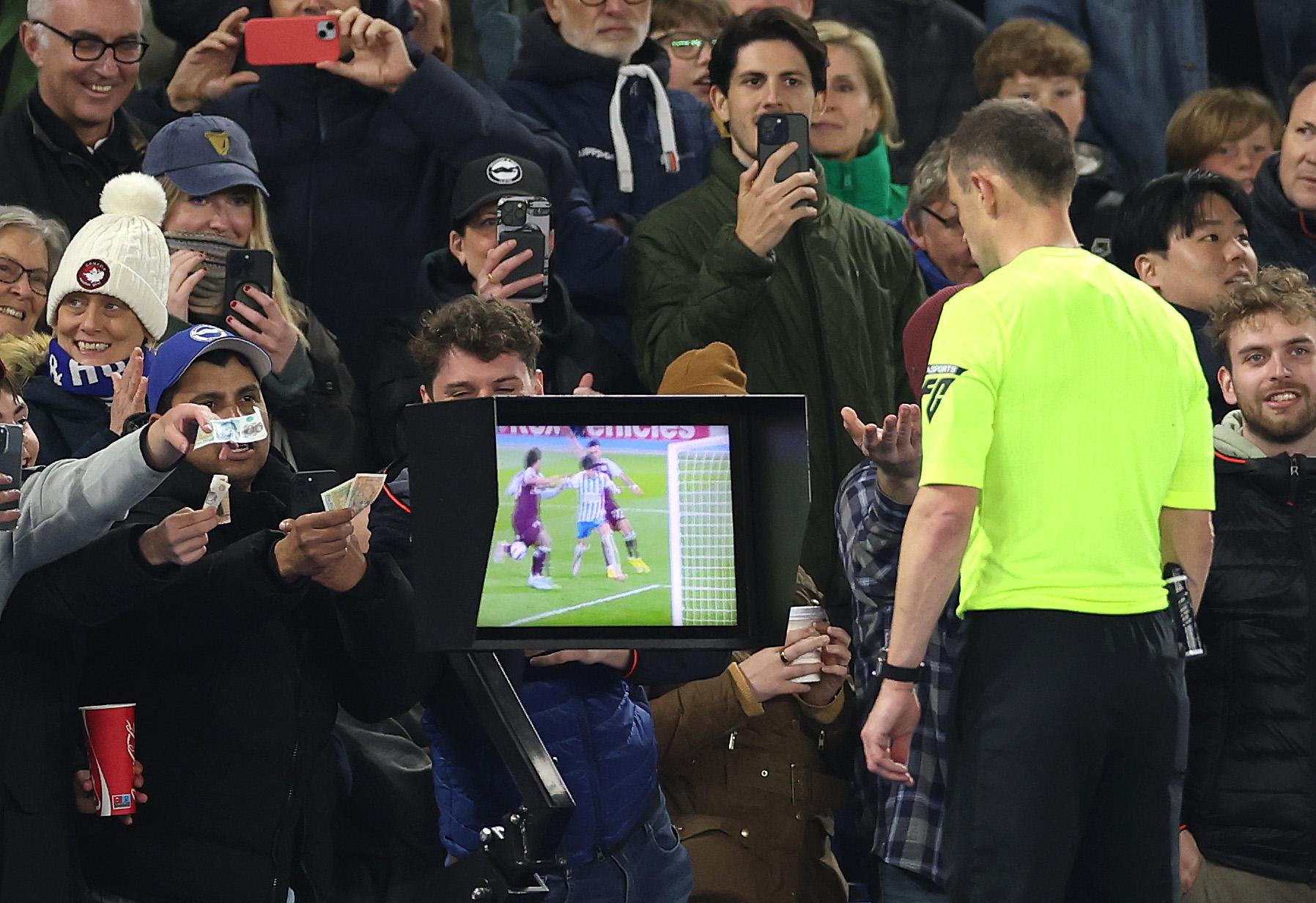 Судья Стюарт Аттуэлл просматривает VAR во время матча АПЛ