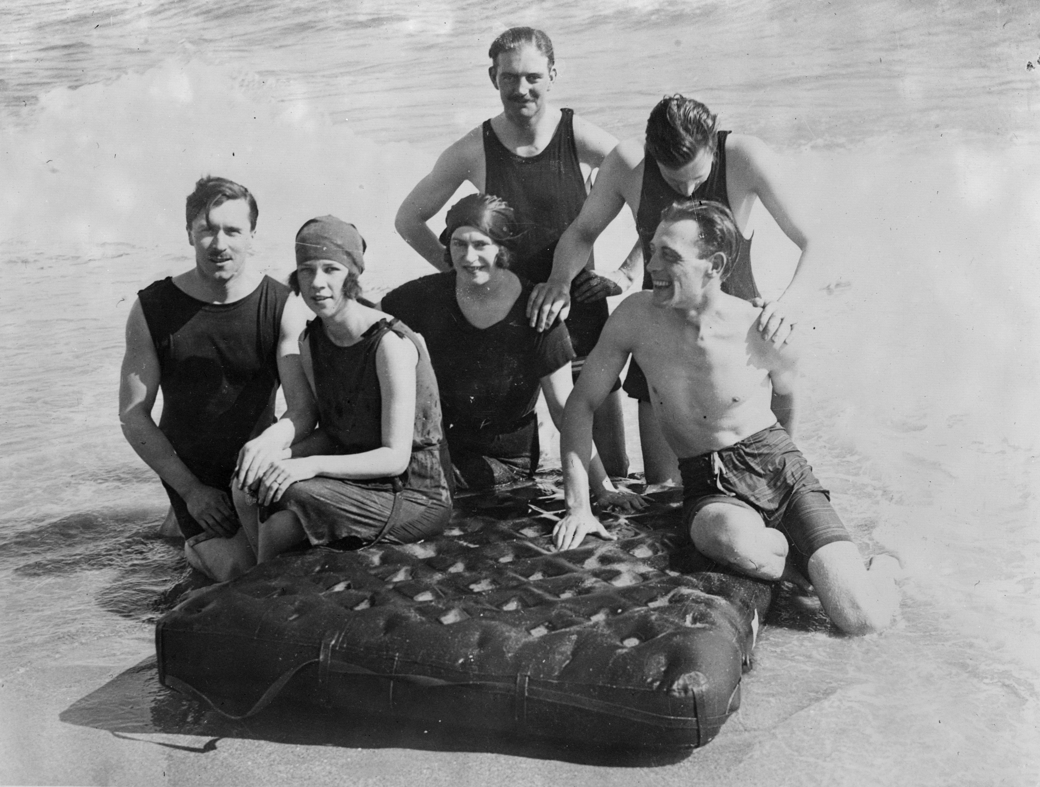 <p>В 1920-е годы пляжный отдых стал веселым времяпрепровождением и даже светским событием. На берегу играли в бадминтон, а по воде передвигались на матрасах. Дресс-код трансформировался в сторону большей открытости: мужчины и женщины теперь&nbsp;носили короткие купальные комбинезоны</p>