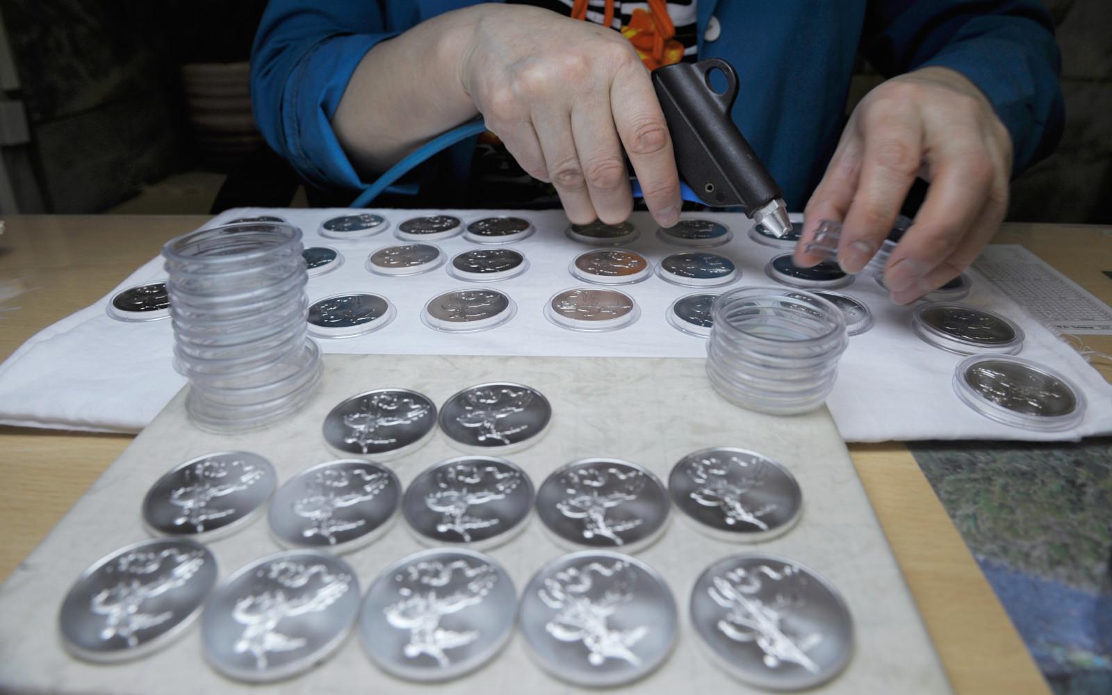 Серебряные коллекционные монеты с изображением Георгия Победоносца в цехе чеканки монет на Московском монетном дворе Гознака