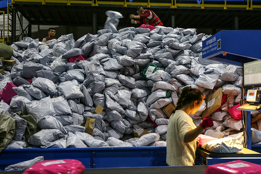 Сотрудники сортируют посылки на складе в городе Иу