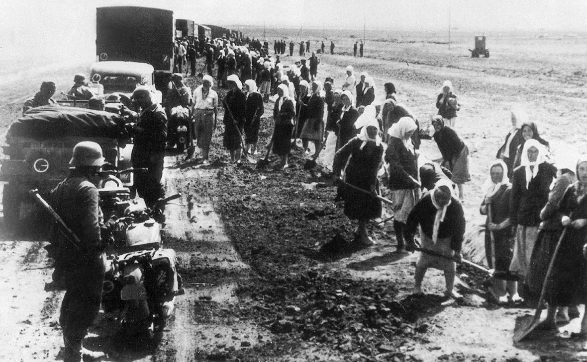 Cоветские граждане на дорожных работах под надзором немецких солдат на оккупированной немецко-фашистской армией территории во время Великой Отечественной войны