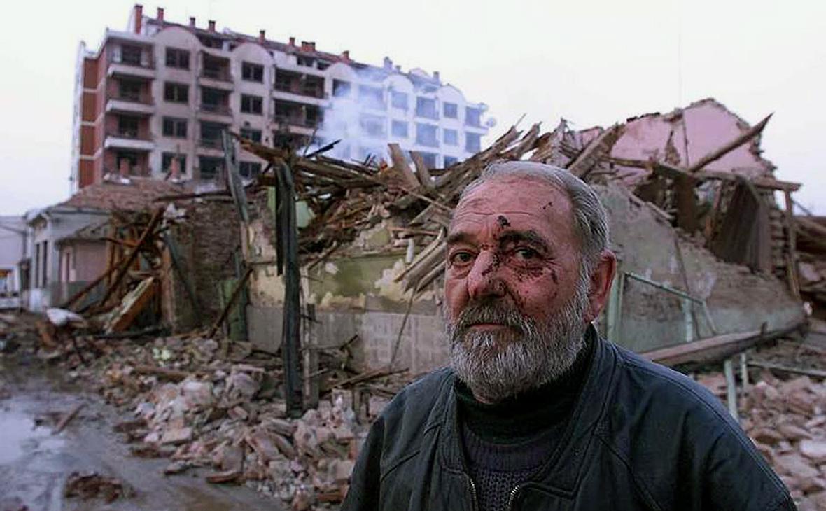 Раненый серб перед разрушенным домом в городе Алексинац, 1999 год