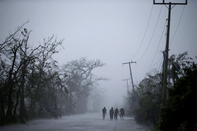 Люди идут под&nbsp;дождем во&nbsp;время урагана &laquo;Мэттью&raquo; в&nbsp;Ле-Ке (Гаити)
