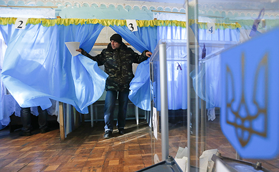 Мужчина выходит из кабинки для голосования в селе Городище Черниговской области, 26 октября 2014г.