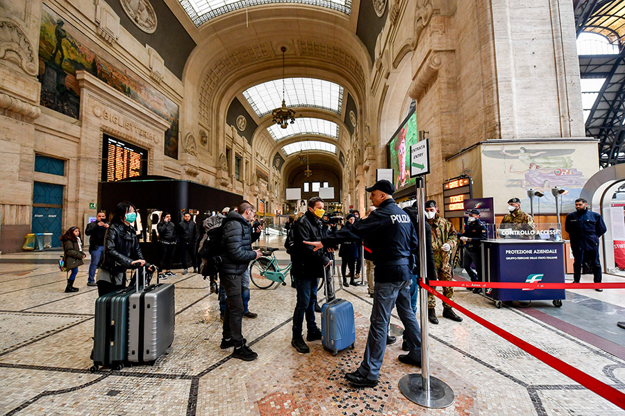 Полицейский следит, чтобы люди на железнодорожном вокзале Милана соблюдали дистанцию: в общественных местах нужно находиться на расстоянии не менее метра друг от друга
