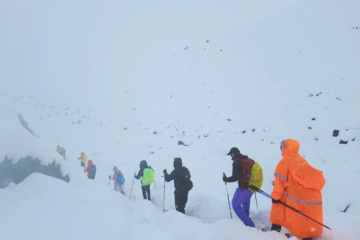 Туристы покидают свой лагерь, когда необычайно сильный снегопад и ливень обрушились на Гималаи в Тибетском регионе, Китай, 5 октября 2025 года