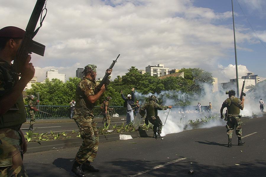 Солдаты Национальной гвардии бросают слезоточивый газ в противников президента Венесуэлы Уго Чавеса за президентским дворцом Мирафлорес в Каракасе, 11 апреля 2002 года