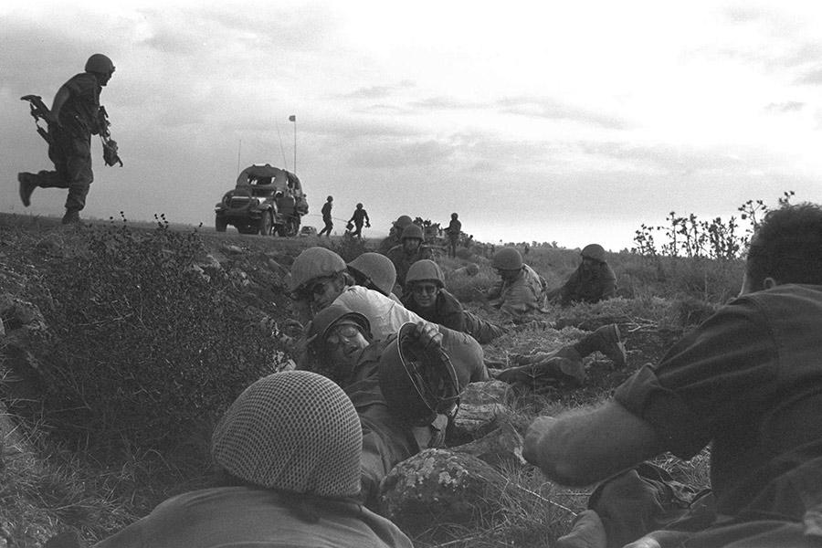 Израильские солдаты прячутся в укрытии, когда сирийские военные самолеты обстреливают их колонну на Голанских высотах, через два дня после начала Войны Судного дня, 1973 год