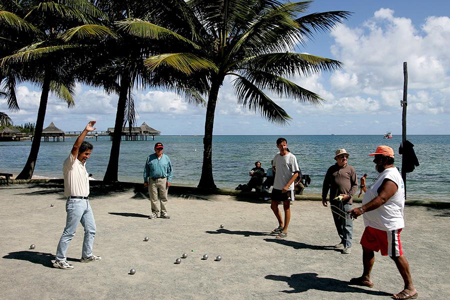Местные жители на пляже в Нумеа играют в традиционную игру в мяч петанк, Новая Каледония, 22 сентября 2005 года
