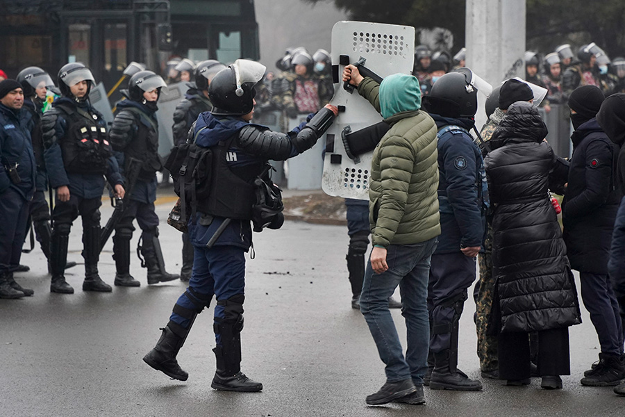 Демонстрант в Алма-Ате возвращает служащему спецподразделения щит