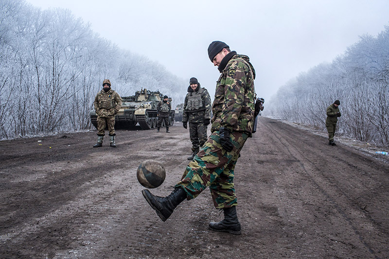 Украинские солдаты играют в футбол на дороге в Дебальцево.
