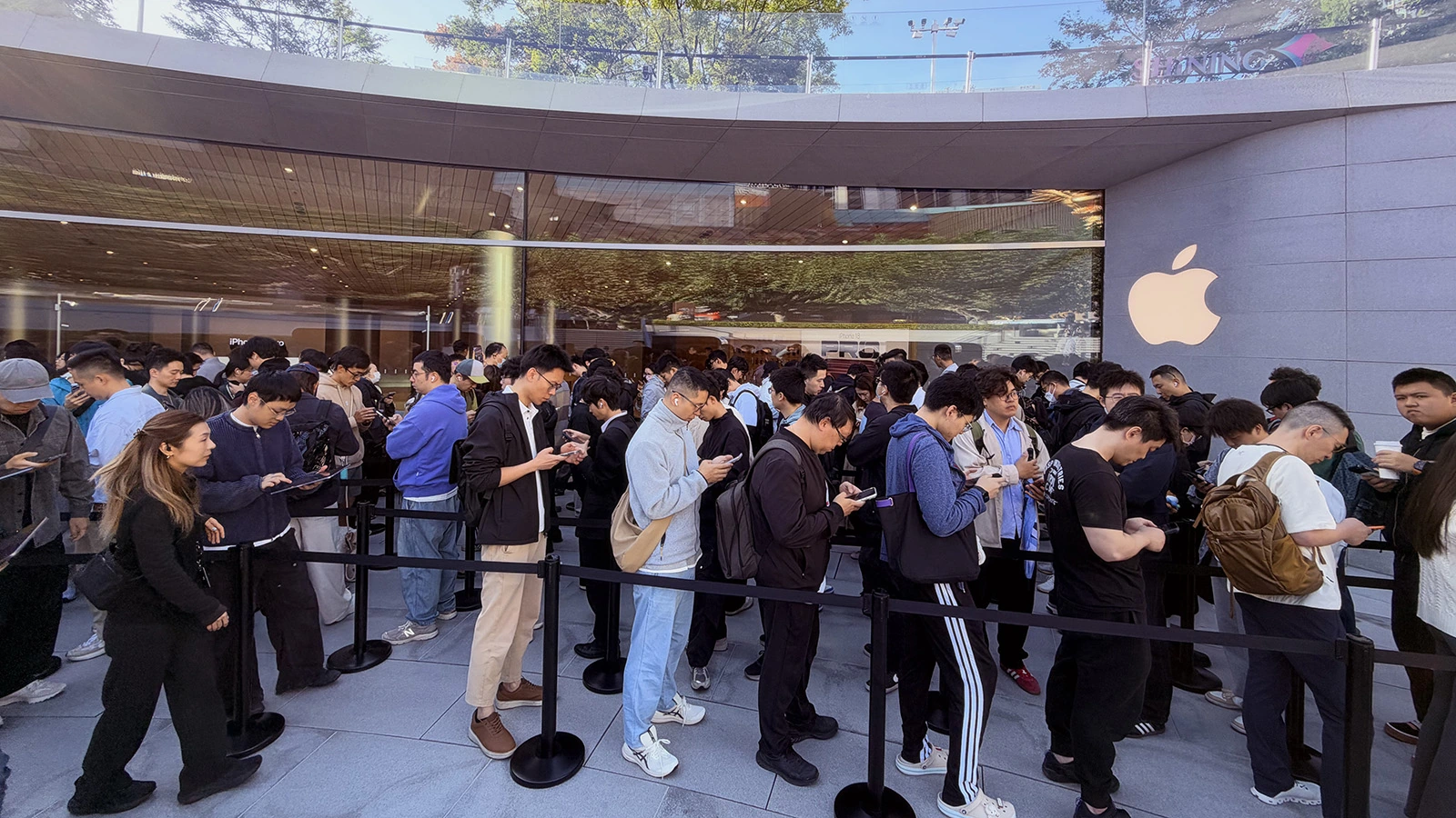 Люди стоят в очереди у розничного магазина Apple, Шанхай, Китай. 23 октября 2025 года