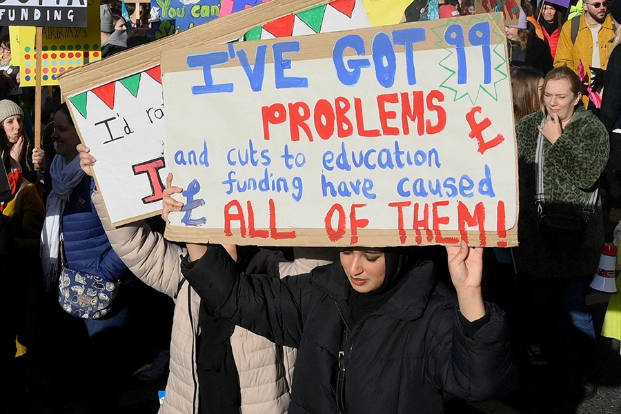 Девушка держит плакат с текстом: &laquo;У меня 99 проблем, и сокращение финансирования образования&nbsp;&mdash; причина всех из них&raquo;
